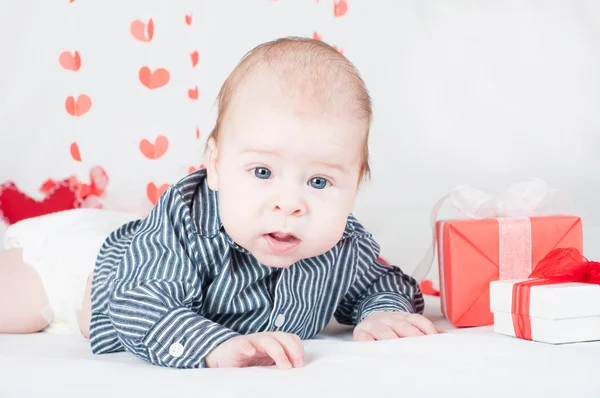 Pojke med en presentask och hjärtan. Alla hjärtans dag koncept — Stockfoto