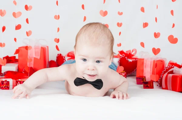 Niño con una caja de regalo y corazones. Concepto de San Valentín — Foto de Stock