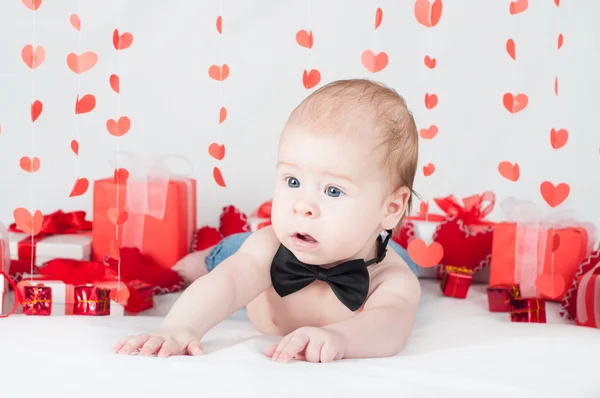 Niño con una caja de regalo y corazones. Concepto de San Valentín — Foto de Stock