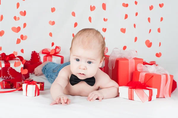 Niño con una caja de regalo y corazones. Concepto de San Valentín —  Fotos de Stock