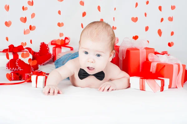 Niño con una caja de regalo y corazones. Concepto de San Valentín —  Fotos de Stock