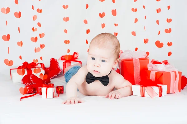 Niño con una caja de regalo y corazones. Concepto de San Valentín —  Fotos de Stock