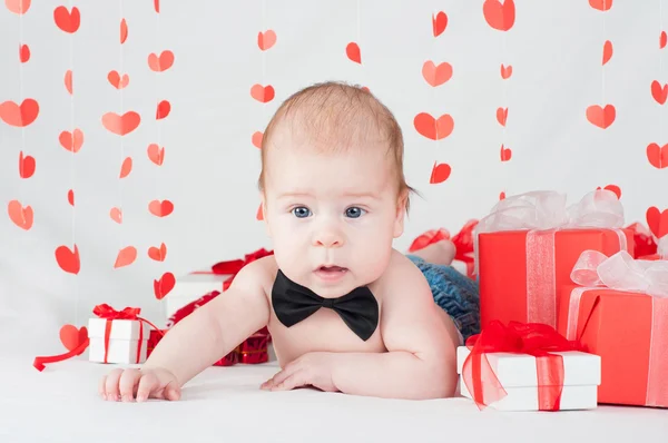 Мальчик с подарочной коробкой и сердцами. День святого Валентина — стоковое фото
