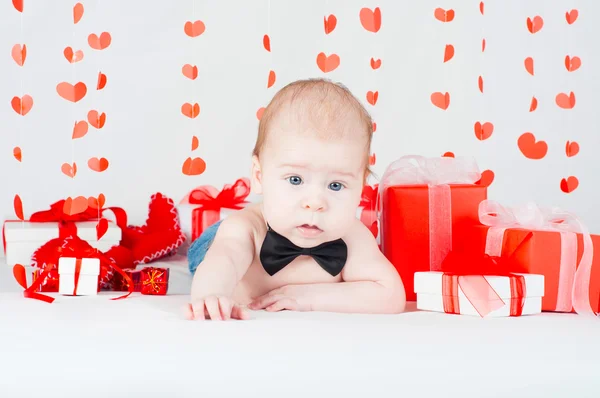 Niño con una caja de regalo y corazones. Concepto de San Valentín — Foto de Stock