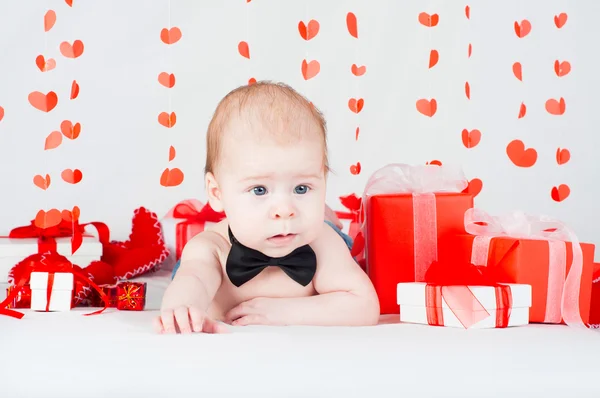 Garçon avec une boîte cadeau et des cœurs. Concept de Saint Valentin — Photo