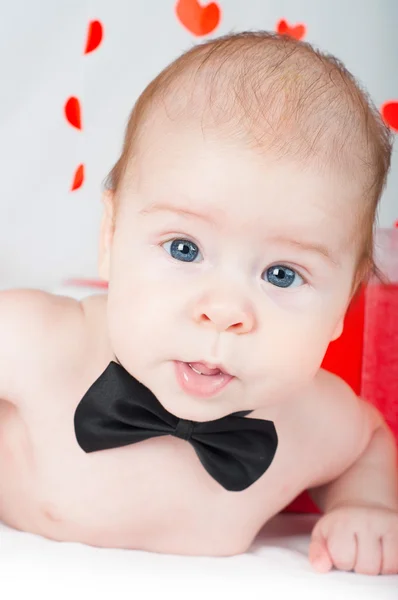 Niño con una caja de regalo y corazones. Concepto de San Valentín —  Fotos de Stock