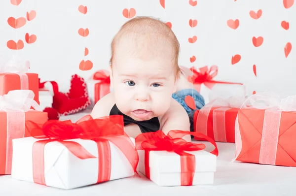 Niño con una caja de regalo y corazones. Concepto de San Valentín — Foto de Stock