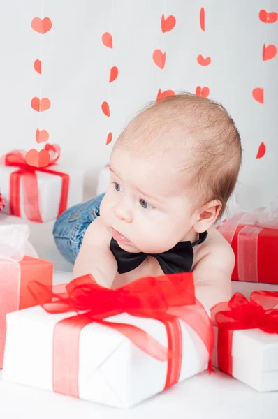 Niño con una caja de regalo y corazones. Concepto de San Valentín — Foto de Stock