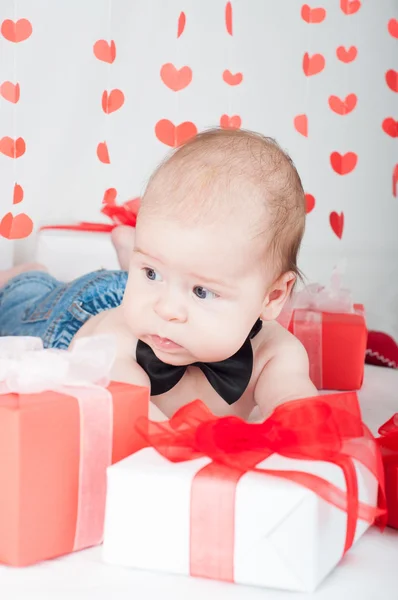 Αγόρι με ένα κουτί δώρου και καρδιές. Έννοια ημέρα του Αγίου Βαλεντίνου — Φωτογραφία Αρχείου