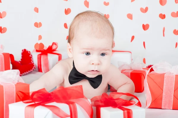 Мальчик с подарочной коробкой и сердцами. День святого Валентина — стоковое фото