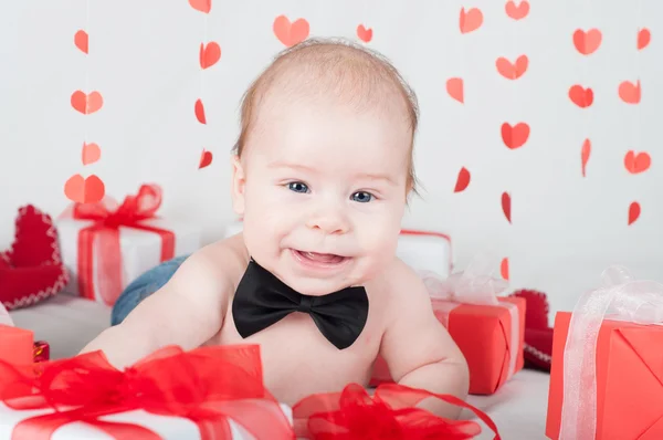 Niño con una caja de regalo y corazones. Concepto de San Valentín — Foto de Stock