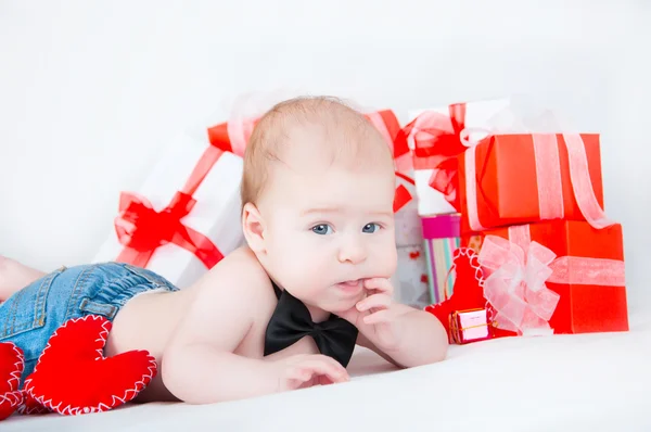 Niño con una caja de regalo y corazones. Concepto de San Valentín —  Fotos de Stock