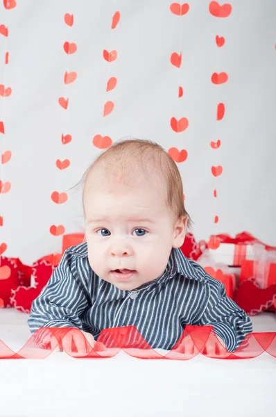 Niño con una caja de regalo y corazones. Concepto de San Valentín — Foto de Stock