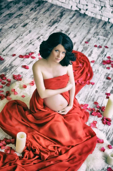 Retrato de uma bela mulher grávida em xale de chiffon vermelho — Fotografia de Stock