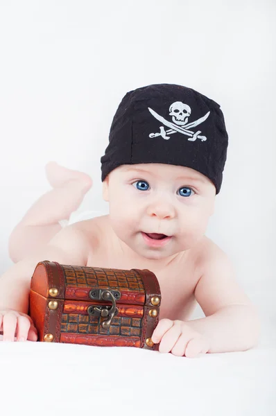 Мальчик в пиратской бандане с сундуком сокровищ на белом фоне — стоковое фото