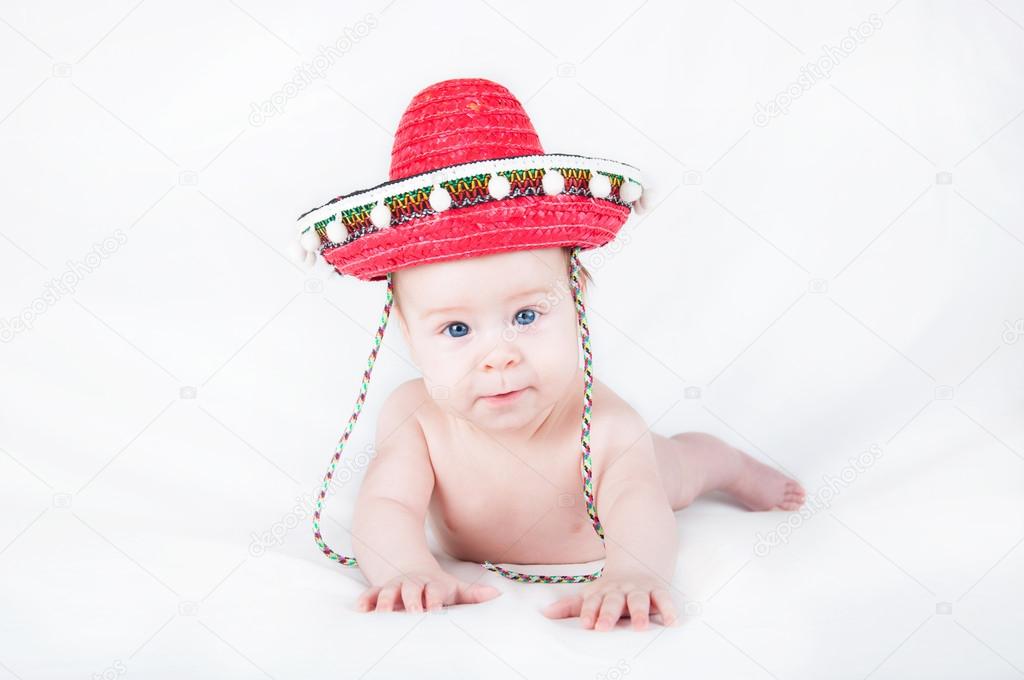 Cheerful little boy with a sombrero and maracas on a white background