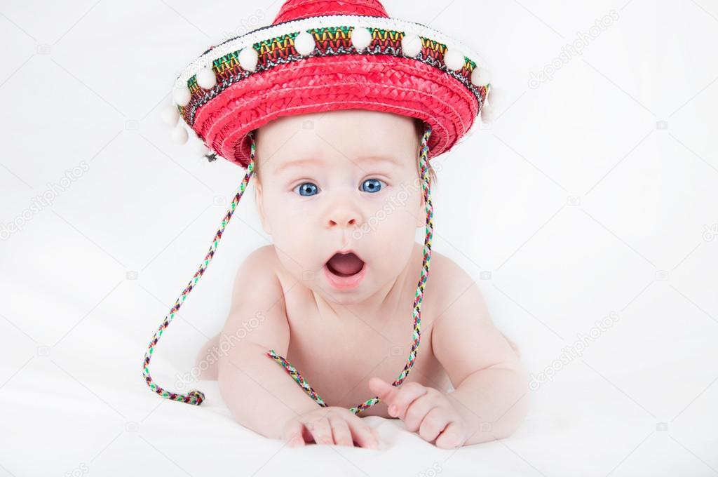 Cheerful little boy with a sombrero and maracas on a white background