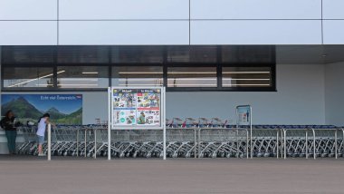Viyana, Avusturya - 10 Temmuz 2015: Viyana 'daki ünlü büyük Alman indirimli marketi Lidl' in dışı tasarımcı Parndorf 'un yanında, insanlar alışveriş arabasıyla içeri girmek için bekliyor. 