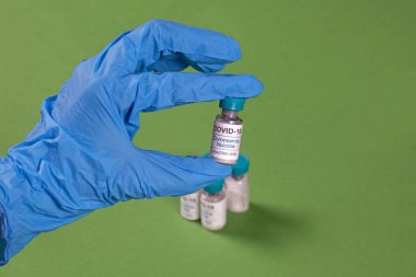 Tıbbi merkezde koronavirüs aşısı tutan lateks eldiven verin.