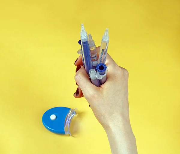女性の手は自宅で歯のホワイトニング手順のためのプラスチック注射器の束を保持 — ストック写真