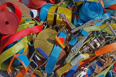 İkinci el pazarında satılan büyük renkli taşıma ekipmanı yığını.