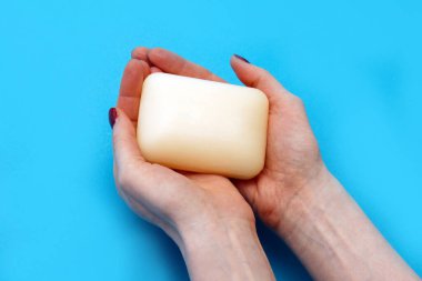 Su altında ellerini yıkamak ve temizlemek için antibakteriyel sabun tutan bir kadın.