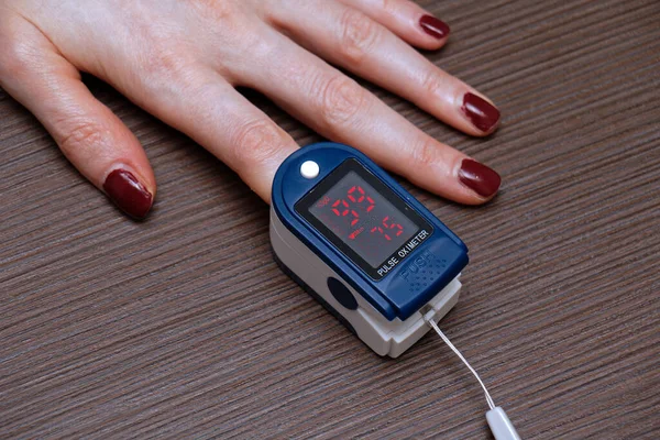 女性手测量红细胞内脉搏和氧饱和度的脉冲血氧计装置 — 图库照片