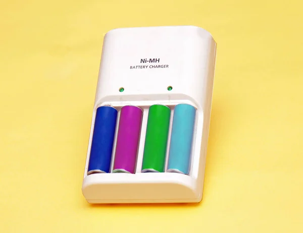 Kolorowe Baterie Litowe Ładowarce Żółtym Tle — Zdjęcie stockowe
