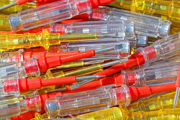 Large pile of plastic electrical testers screwdrivers on market stall