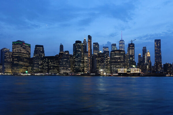 View of lower Manhattan skyline from East river coast during night