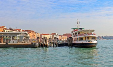 Venedik, İtalya - 09 Ocak 2017: Venedik buharlı su otobüsü durağında bekleyen turistler yaklaşan tekneye binmek için bekliyorlar. Venedik ACTV ulaşım yetkilileri Vaporetto su yolu şebekesini 19 tarifeli hatla yönetiyor..