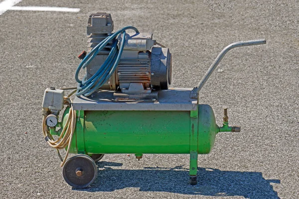 Air compressor in metal container outdoors on pavement