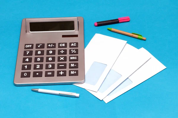 Pile White Blank Envelopes Electronic Calculator Pens Blue Background — Stock Photo, Image