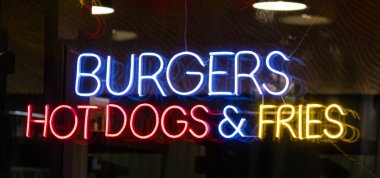 Şehir caddesinde gece boyunca renkli, parlayan neon tabelalar. 