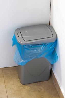 Modern odanın iç kısmının köşesinde kapalı plastik çöp kutusu.