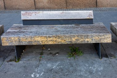Empty bench with wooden flat seat surface outside on a street