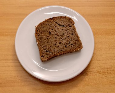 Seramik tabakta tam tahıllı çavdar ekmeği dilimi kes