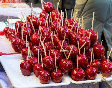 Elmalar çubuk üzerinde klasik bir ikram. Bütün kırmızı elmalar sert karamel şekerlerle kaplı. Bir markette satılıyor.