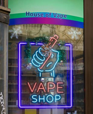 Belgrad, Sırbistan - 13 Ocak. 2026: VAPE mağaza önü tabelasının üzerinde, Sırbistan 'ın başkenti Belgrad' da bir caddede bir el bilgisayarı tutan bir elin grafiğini içeren VAPE mağazası LED neon levhası bulunuyor.