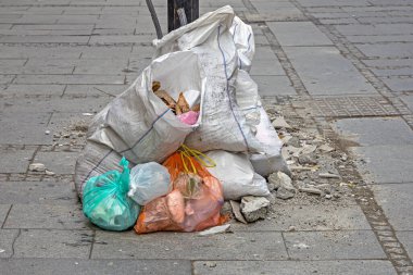 Kirli plastik çöp torbaları şehir kaldırımlarında yığılıyor.