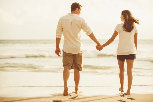 Couple romantique sur la plage au coucher du soleil . — Photo