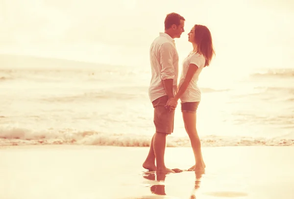 Pareja romántica en la playa al atardecer . — Foto de Stock