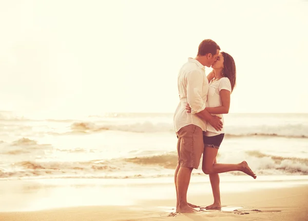 Couple romantique sur la plage au coucher du soleil . — Photo