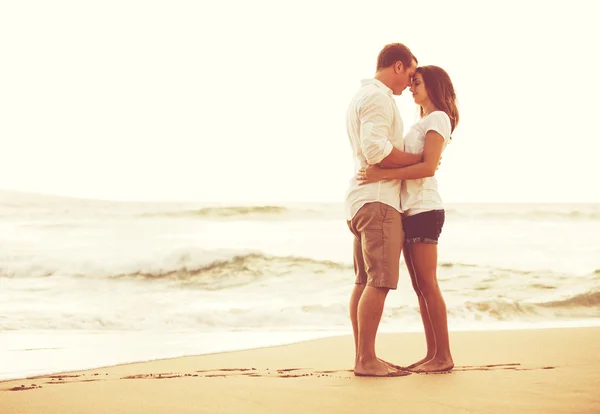 Couple romantique sur la plage au coucher du soleil . — Photo