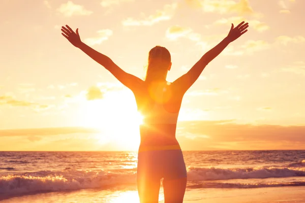 Feliz mulher livre ao pôr do sol na praia — Fotografia de Stock