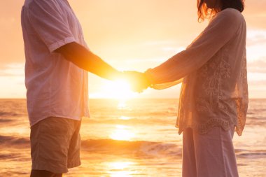 Senior Couple Holding Hands Enjoying at Sunset clipart