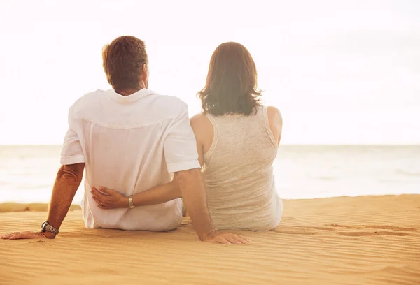 Pareja madura disfrutando de la puesta de sol en la playa — Foto de Stock