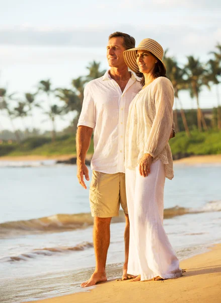 Pareja madura disfrutando de la puesta de sol en la playa — Foto de Stock