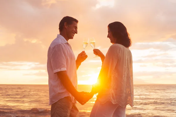 Coppia godendo bicchiere di Champene sulla spiaggia al tramonto — Foto Stock