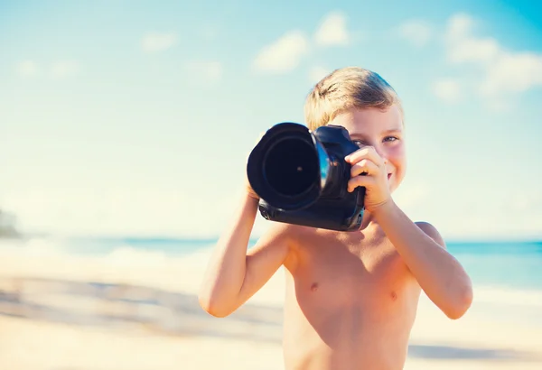 Pojke på stranden med kamera — Stockfoto